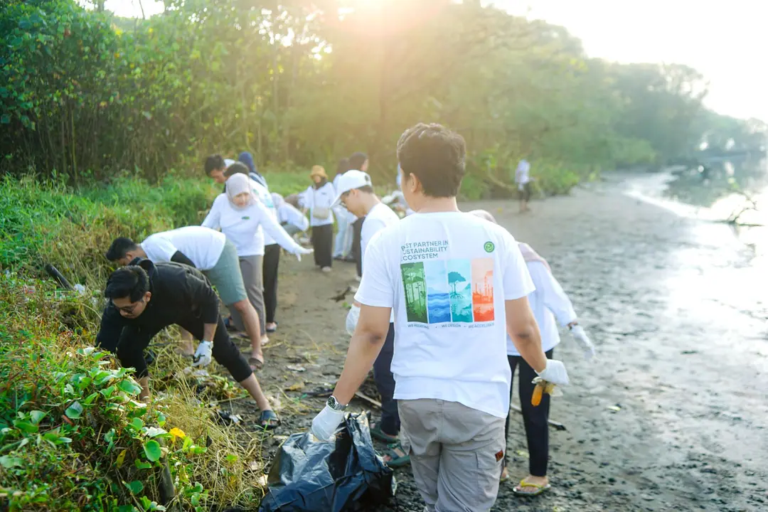 Relawan membersihkan sampah di tepi pantai